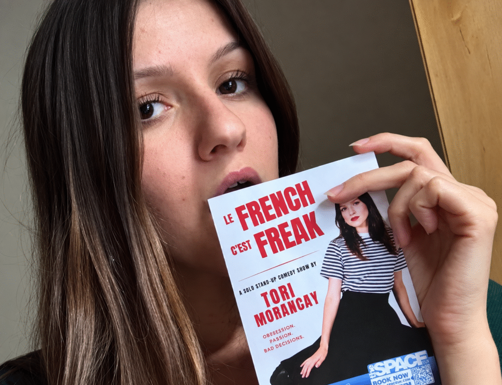Tori Morancay holding a flyer for her show Le French C'est Freak