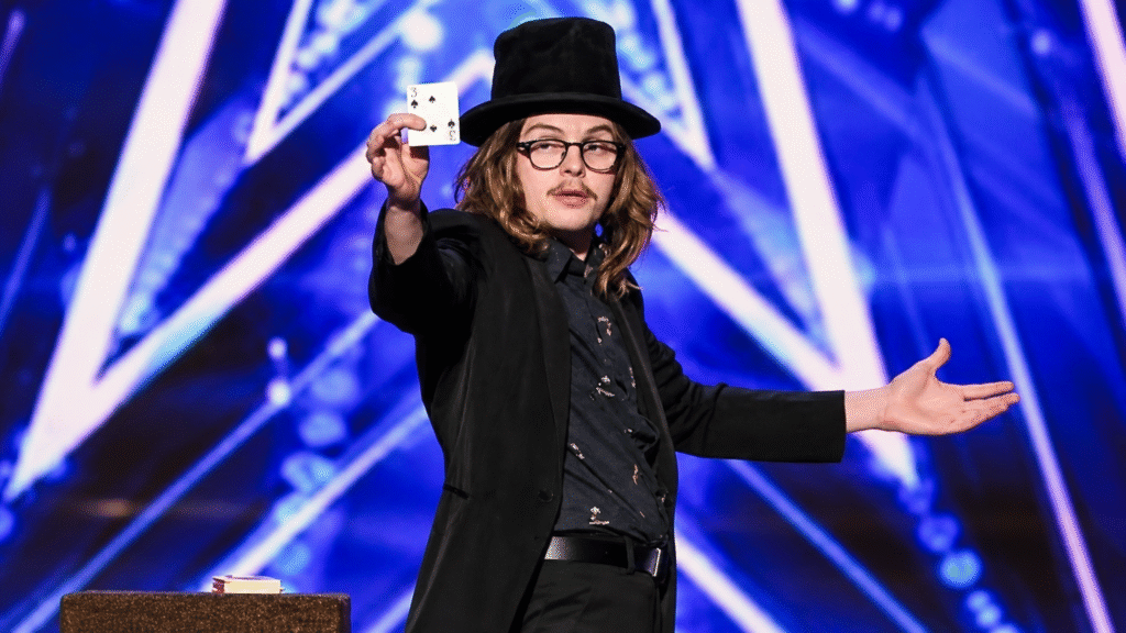 Jack Grady in a top hat performing a magic trick on the America's Got Talent stage