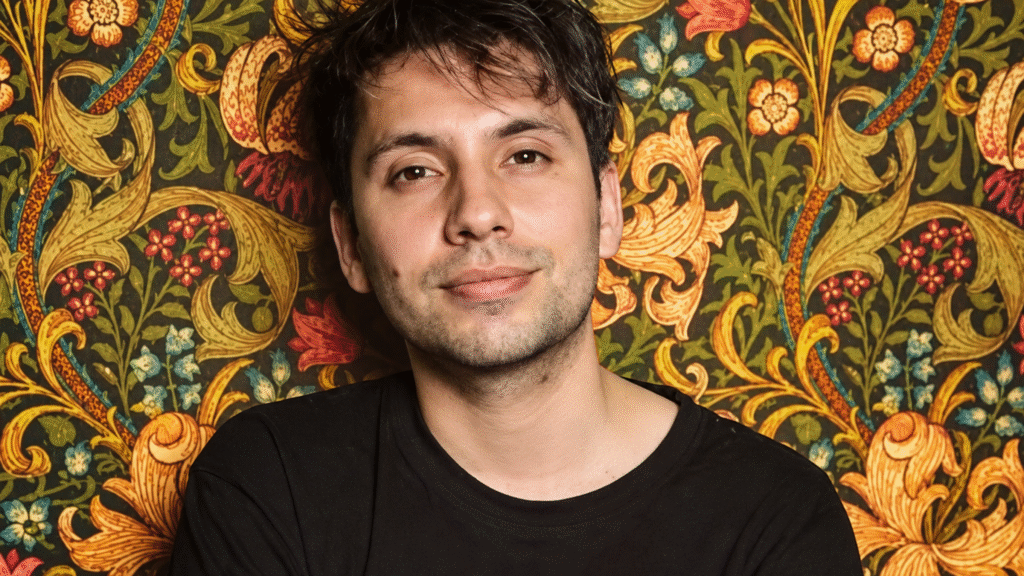 Portrait of Fabrizio Copano against floral wallpaper