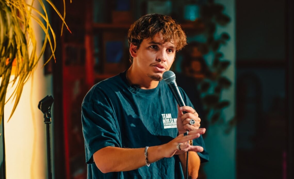 André De Freitas performing stand-up with a microphone