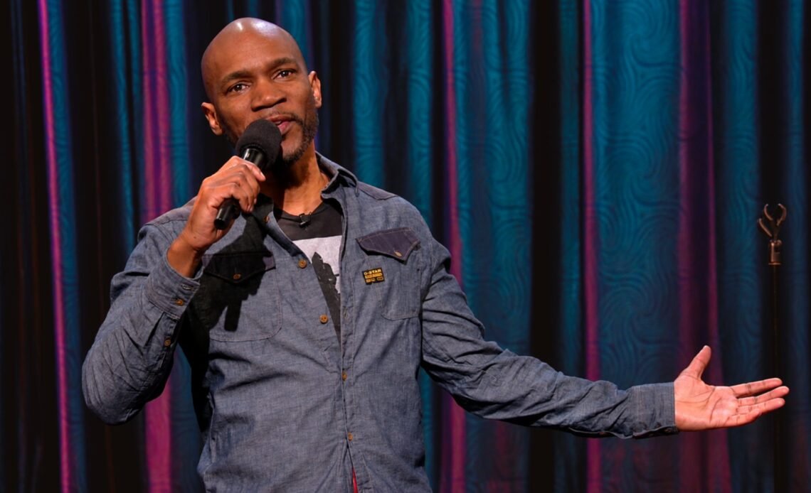 Ian Edwards holding a microphone during a stand-up set