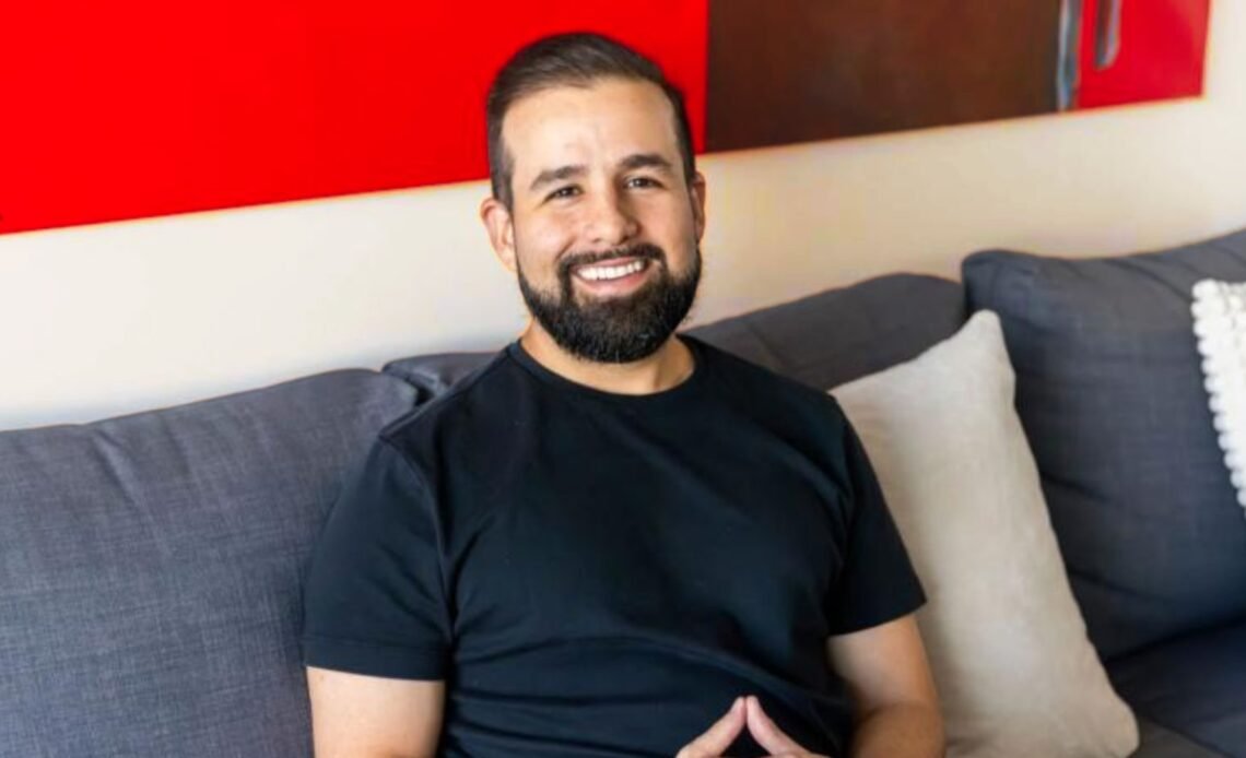 Stephan Dyer sitting on a sofa, smiling