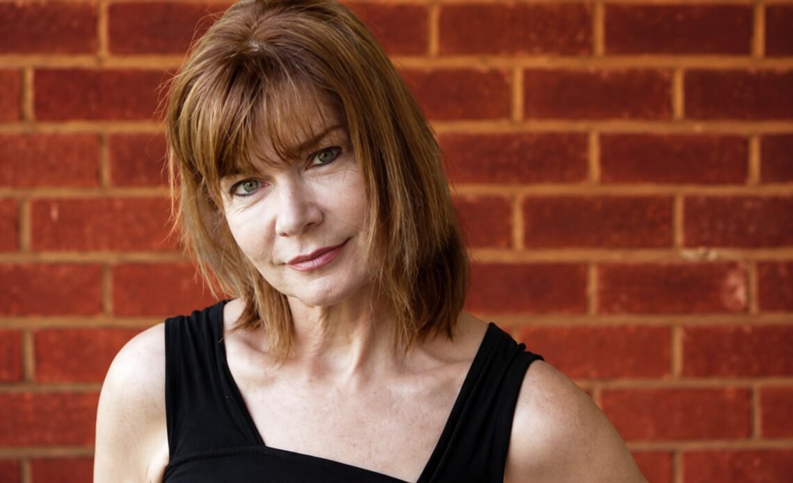 Portrait of comedian Vanessa Hollingshead in front of a brick wall
